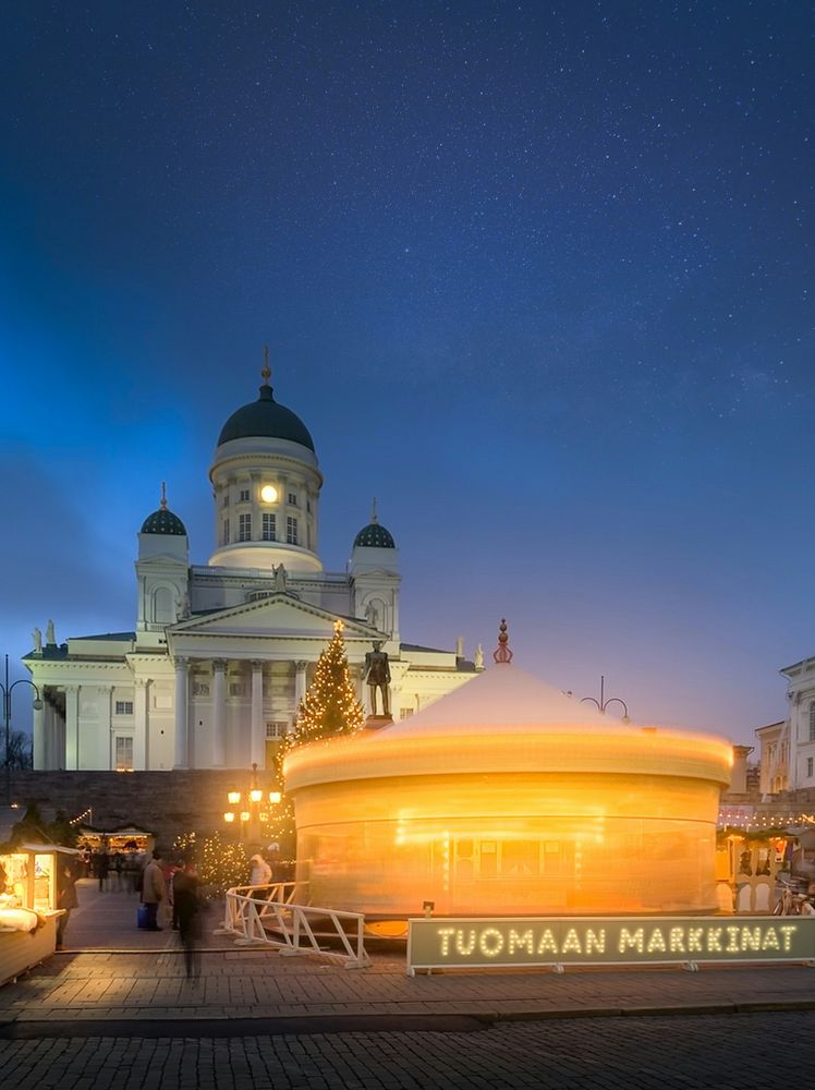 Der Dom von Helsinki in der blauen Stunde, davor der beleuchtete Pavillon des Weihnachtsmarkts